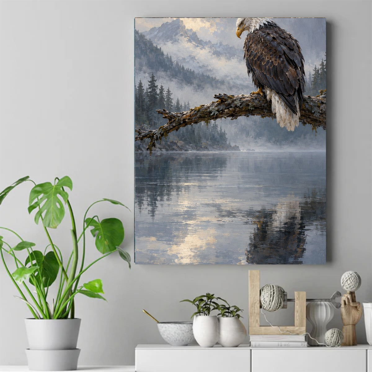 Bald eagle perched on a moss-covered branch over a still misty lake, with mountains and pine trees behind it – ảnh 2