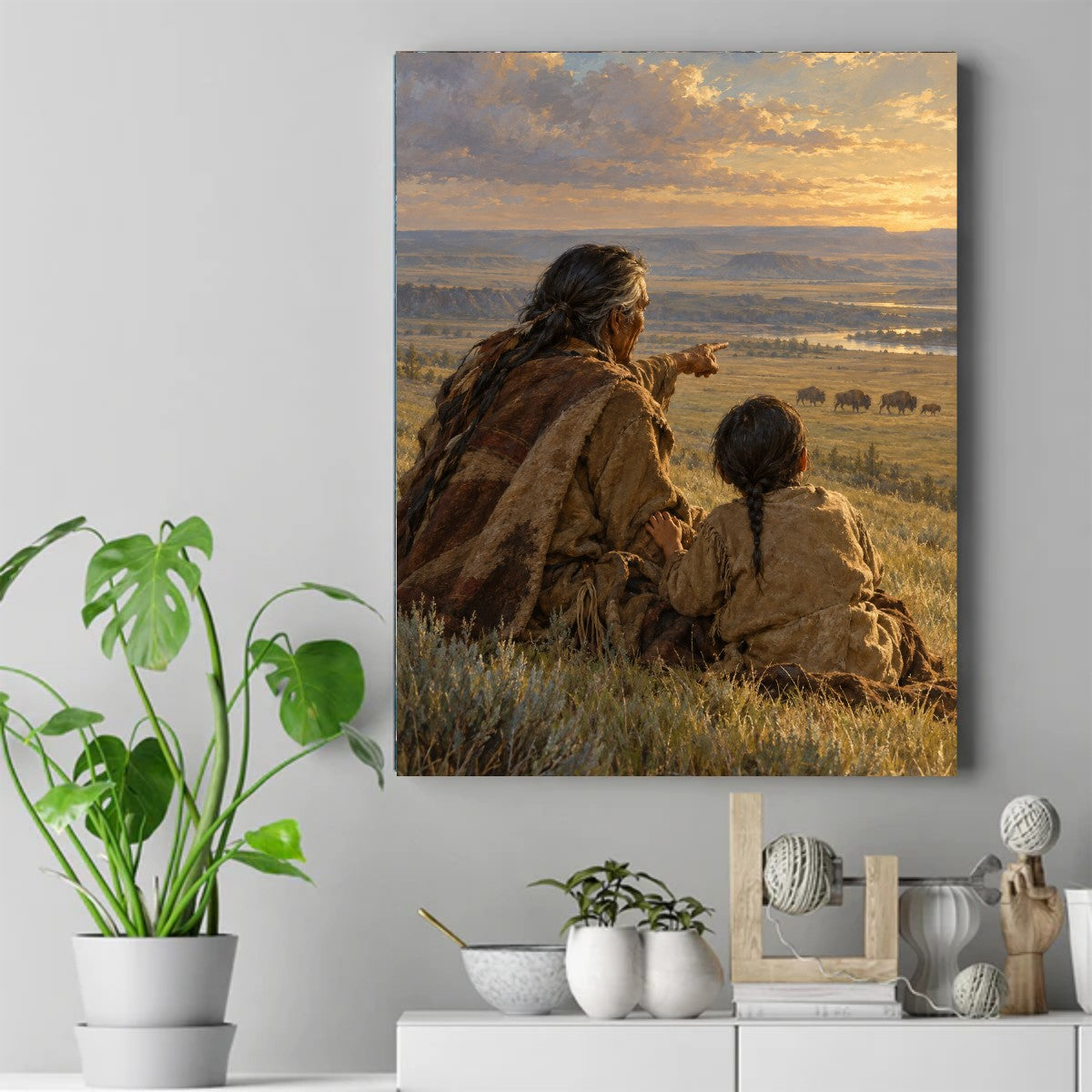 Elder with braided hair points toward grazing buffalo as a child sits close beside him under a golden sunset sky. – ảnh 2