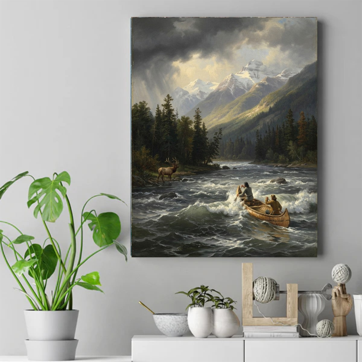 Two Native men paddling a canoe through foaming river rapids, with an elk on the bank and snow-capped mountains behind. – ảnh 2