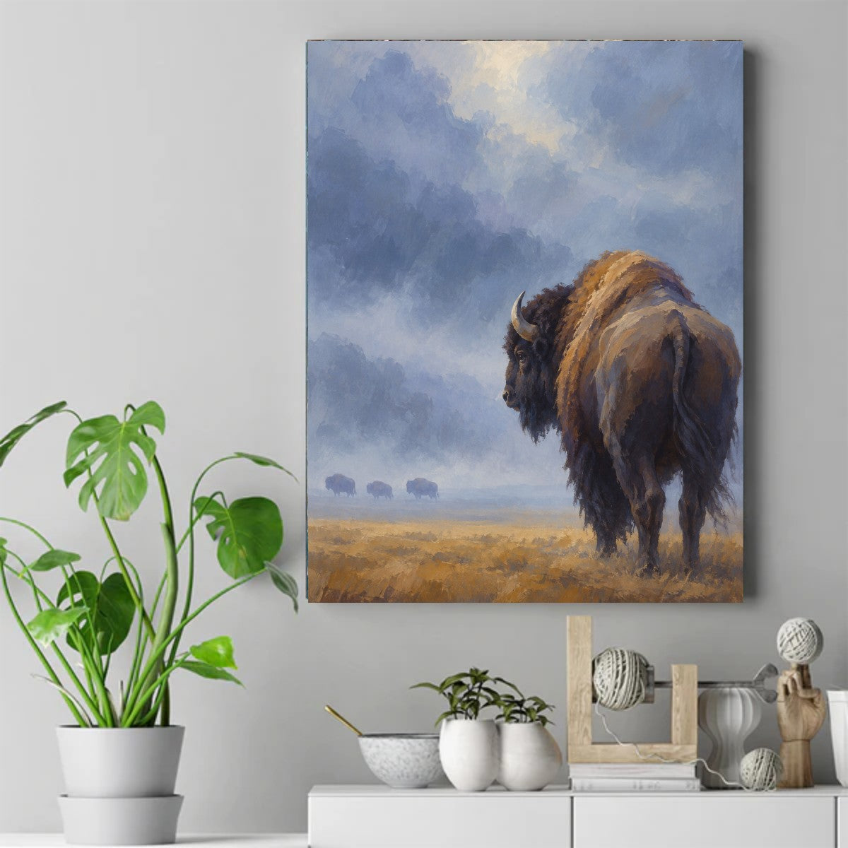 Lone bison with a golden hump standing in tall prairie grass under stormy blue-grey clouds, three bison far in the distance – ảnh 2
