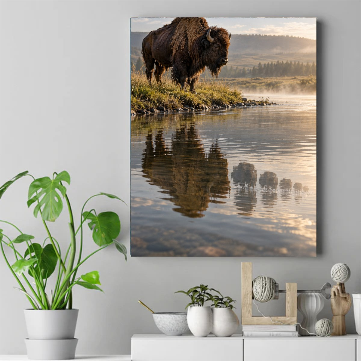 Bison on a grassy riverbank at sunrise with its reflection in calm water and mist rising behind – ảnh 2