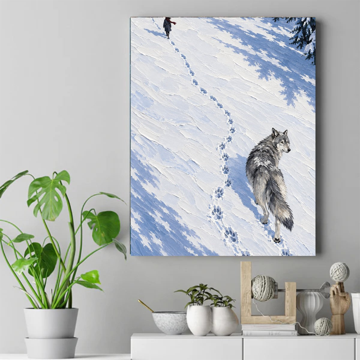 Wolf standing on snow looking back toward a person walking up a snowy slope, with tracks between them. – ảnh 2