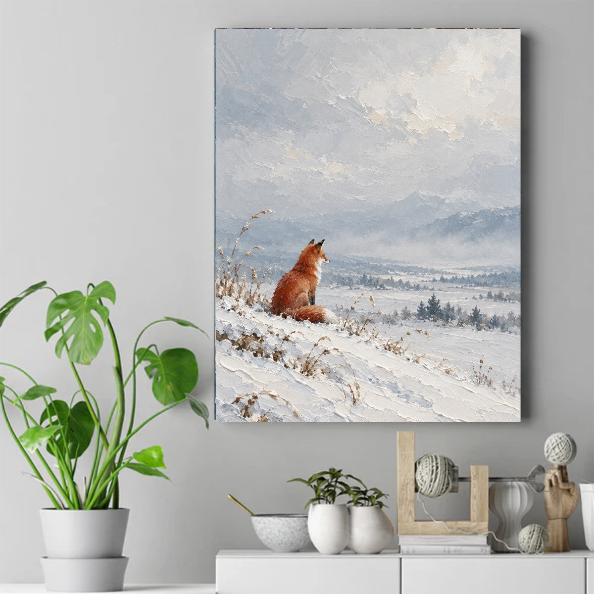 Red fox sitting on a snow-covered slope, looking toward foggy mountains under a soft gray sky. – ảnh 2