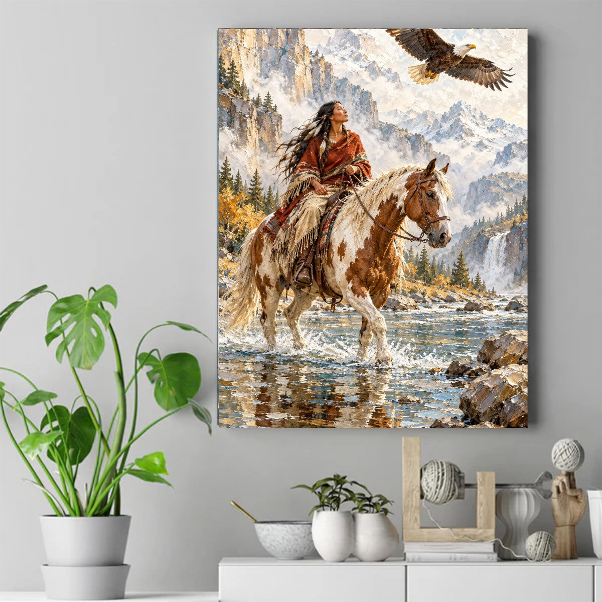Native woman in a red blanket on a paint horse in a river, looking up at a bald eagle, snowy mountains behind – ảnh 2